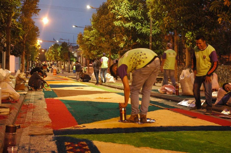 Sobre la sexta avenida de la zona 1, desde la madrugada decenas de guatemaltecos elaboran la alfombra más larga. (Foto: Fredy Hernández/ Soy502)