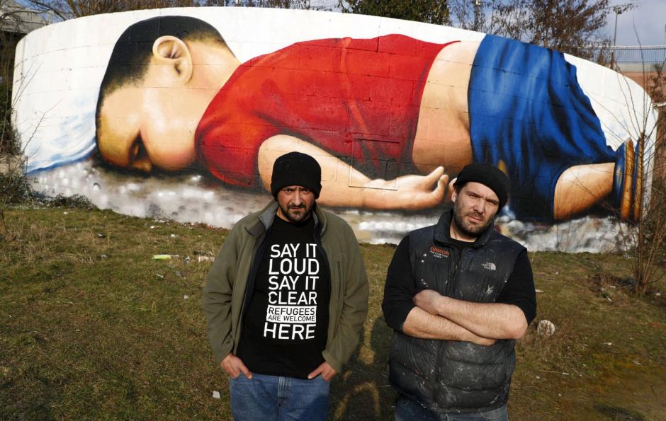 Los artistas Justus Becker, a la derecha, y Oguz Sen este jueves frente al grafiti de Aylan en Fr&aacute;ncfort. (Foto: El pa&iacute;s)