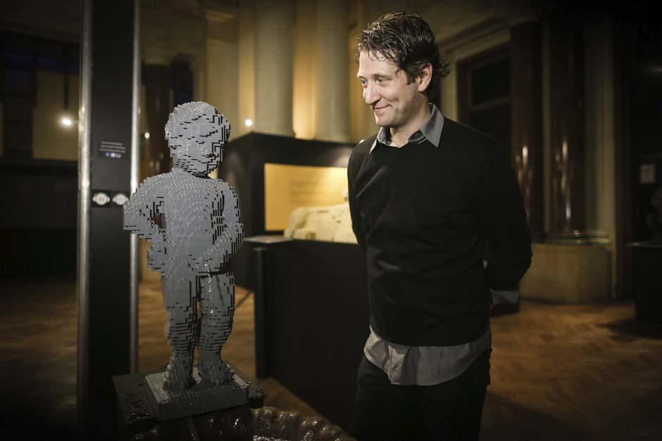 Nathan Sawaya posa junto a una escultura titulada "Manneken Pis". (Julien Warnand/EFE)