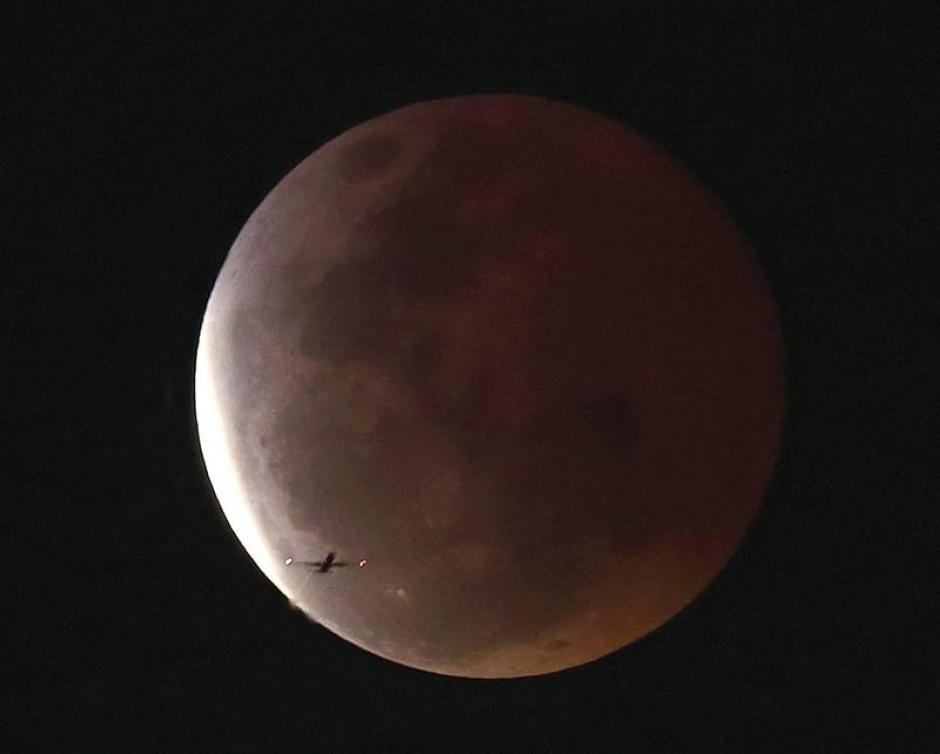 En la imagen se observa como un avi&oacute;n vuela en la provincia de Pathum Thani, en las afueras de Bangkok, Tailandia en el momento del eclipse lunar. &nbsp;(Foto: EFE)&nbsp;