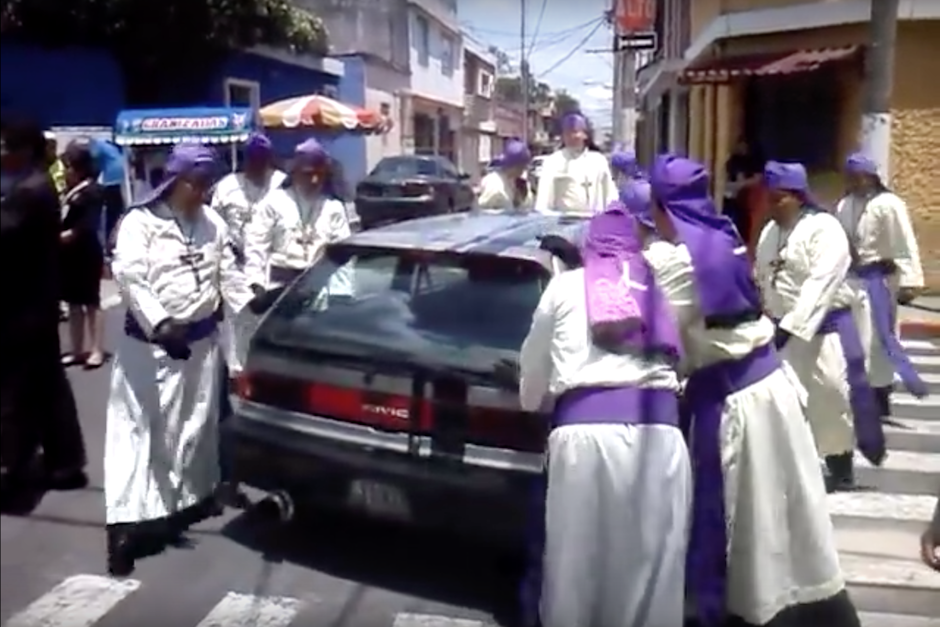 Imagen de 2015 donde una de las comisiones rompev&iacute;as mueve un veh&iacute;culo que obstuye el paso del cortejo procesional. (Imagen: captura de pantalla)