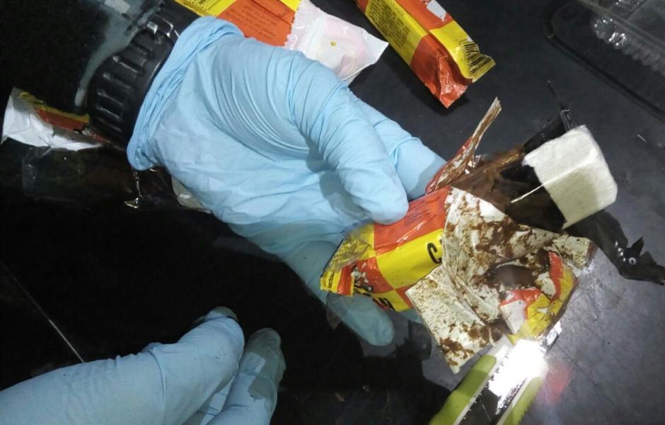 Un agente de la polic&iacute;a muestra la barra del popular chocolate que sirvi&oacute; para ocultar la coca&iacute;na. (Foto: PNC)&nbsp;