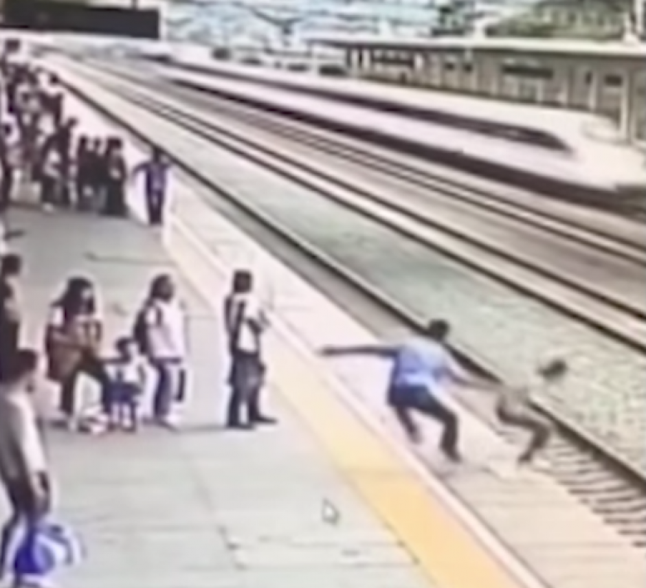 El hombre atrap&oacute; a la mujer antes que pudiera lanzarse a las v&iacute;as del tren. (Foto: Captura de pantalla)&nbsp;