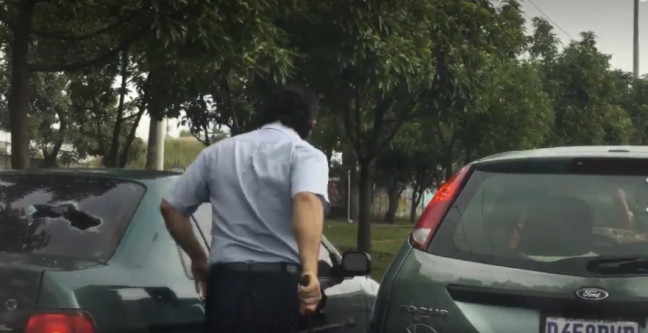 Conductor rompe el vidrio de un autom&oacute;vil con el que choc&oacute; minutos antes en la calzada Atanasio Tzul. (Foto: Captura de video)