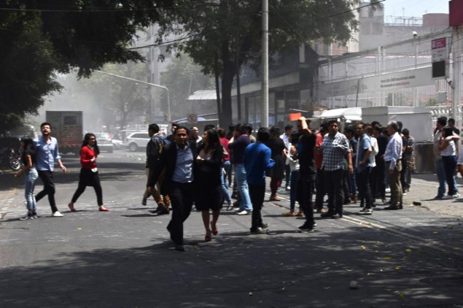 Varias personas salen de los establecimientos mientras otros lugares se desploman. (Foto: AFP)&nbsp;