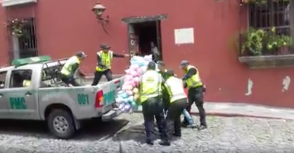 Un grupo de agentes de la Polic&iacute;a Municipal de Antigua Guatemala arrebata la venta de dulces de algod&oacute;n a un comerciante informal. (Foto: captura de pantalla).&nbsp;