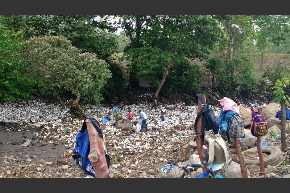 Varias personas observan la gran cantidad de basura que arrastra el r&iacute;o. (Foto: Ingenios El Pilar y Magdalena)