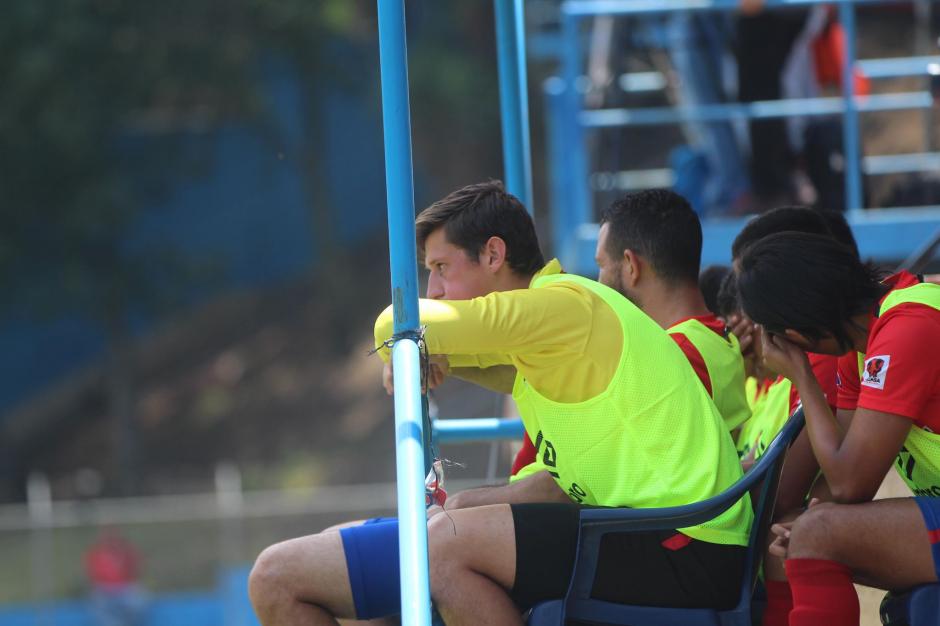 Nicholas Hagen ve el partido de los rojos desde la banca por decisión de Hernán Medford. (Foto: Soy502)