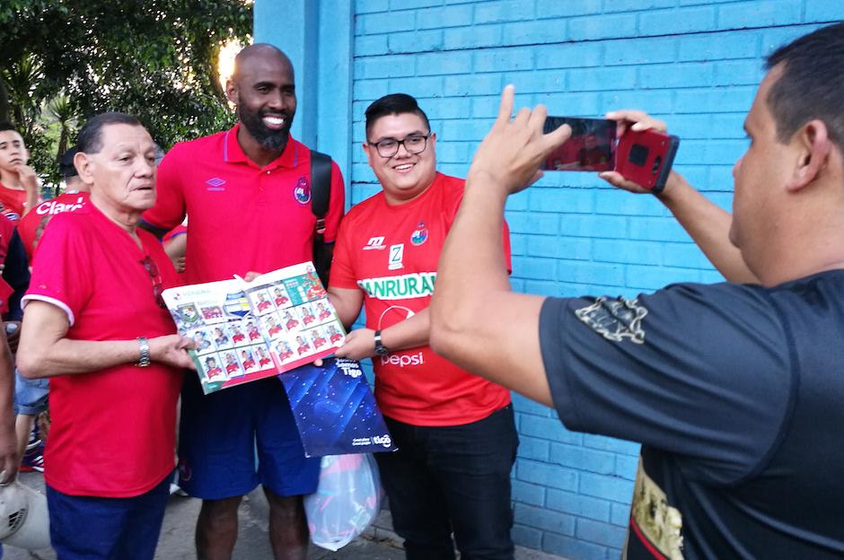 Felipe Baloy posa con aficionados de Municipal y el álbum mundialista. (Foto: Rudy Martínez/Soy502)