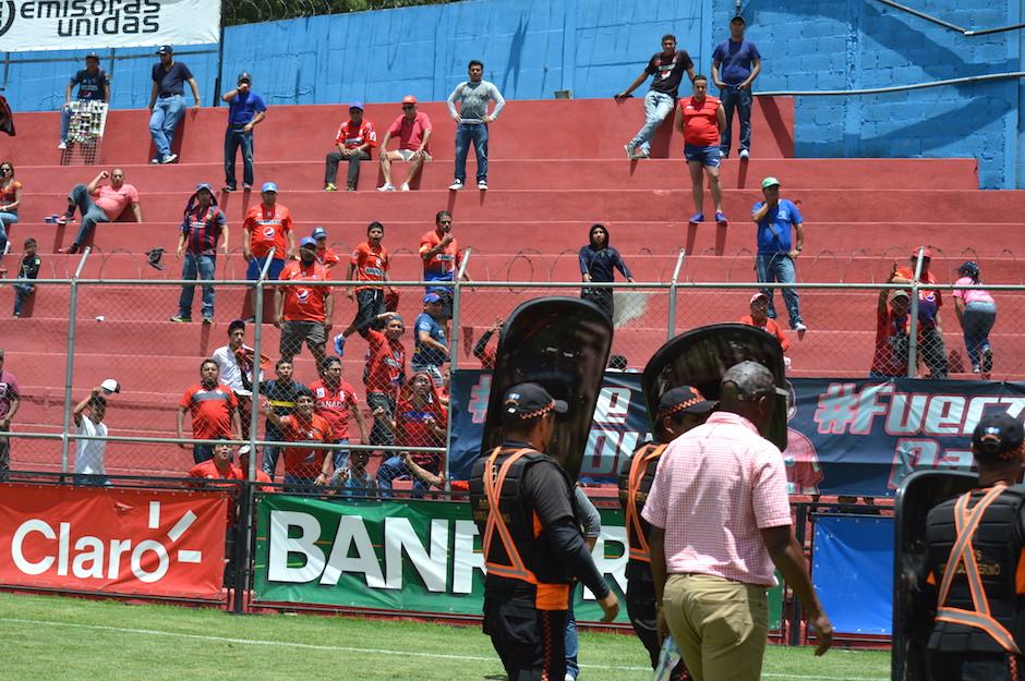 El técnico costarricense Hernán Medford sale resguardado por guardias de seguridad, mientras la afición le reclama. (Foto: Rudy Martínez/Soy502)