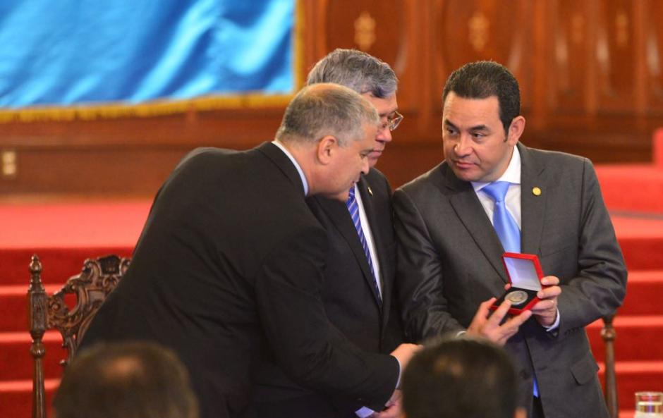 Jimmy Morales muestra la moneda durante el acto de entrega. (Foto: Jes&uacute;s Alfonso/Soy502)