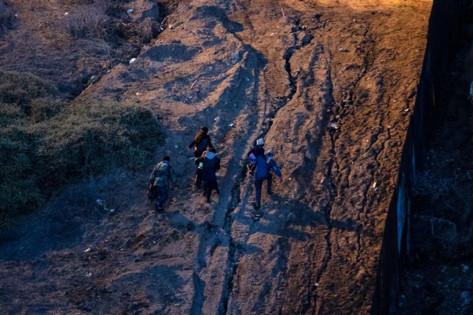 Un grupo de inmigrantes corren tras cruzar la frontera en Estados Unidos. (Foto: AFP)