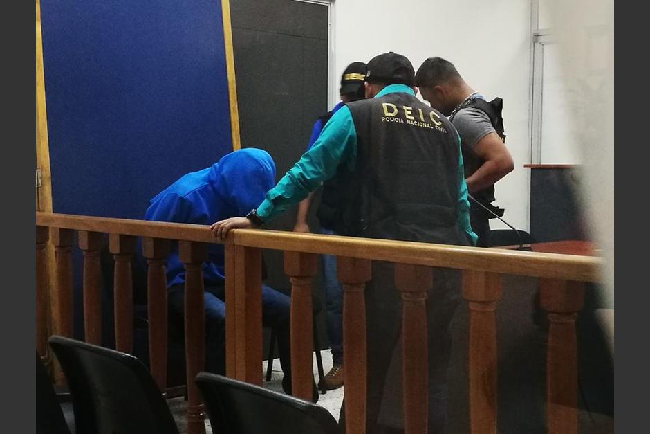 Con un suéter con capuchón tratando de cubrir su rostro, Marco Pappa fue llevado por la PNC al juzgado de femicidio. (Foto: Wilder López/Soy502)