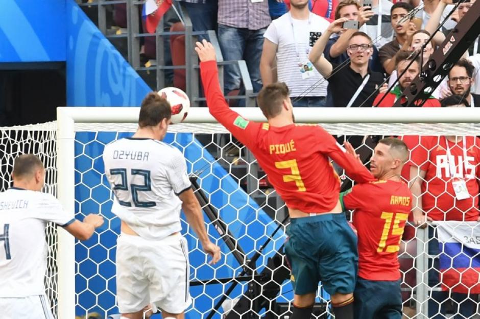 Piqué salta con la mano arriba, el balón impacta y el árbitro marca penal. (Foto: AFP)