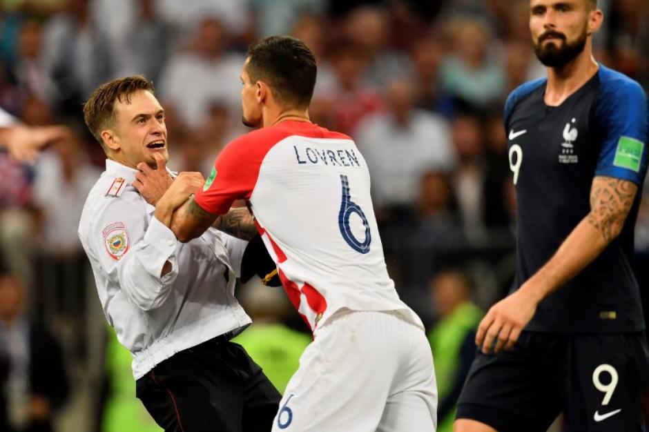 El jugador croata Lovren empuja a un aficionado que ingresó a la cancha del estadio Luzhniki. (Foto: AFP)