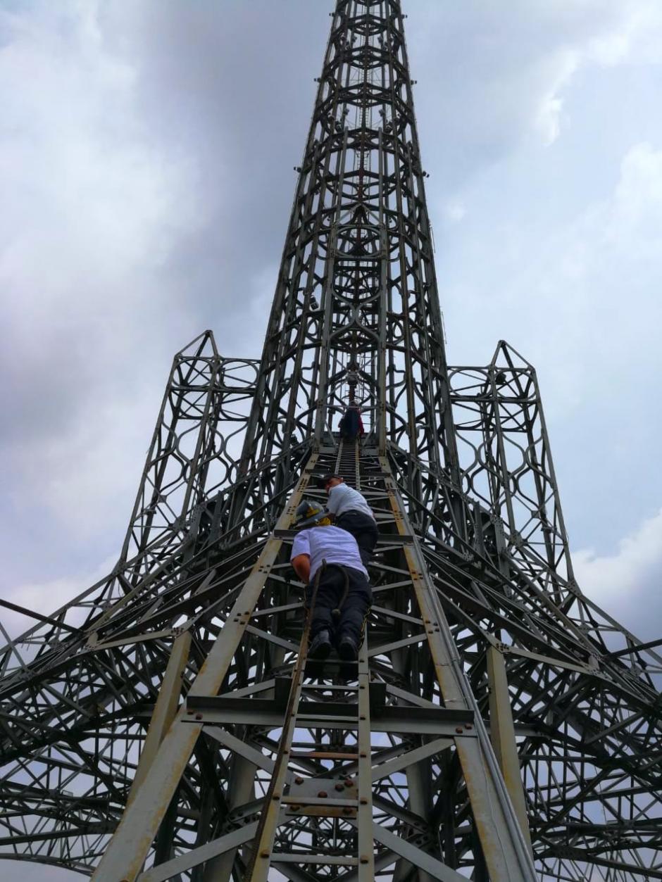 Bomberos ayudan a un hombre a bajar de la Torre del Reformador luego de que la escalara bajo efectos de estupefacientes. (Foto: Bomberos Voluntarios)