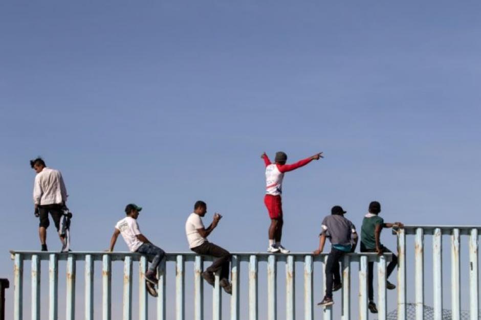 Migrantes en Tijuana se subieron sobre las vallas fronterizas entre M&eacute;xico y EE.UU. (Foto: AFP)