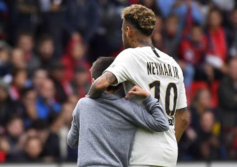 El brasileño Neymar abraza a un niño que se coló a la gramilla para abrazarlo. (Foto: AFP)