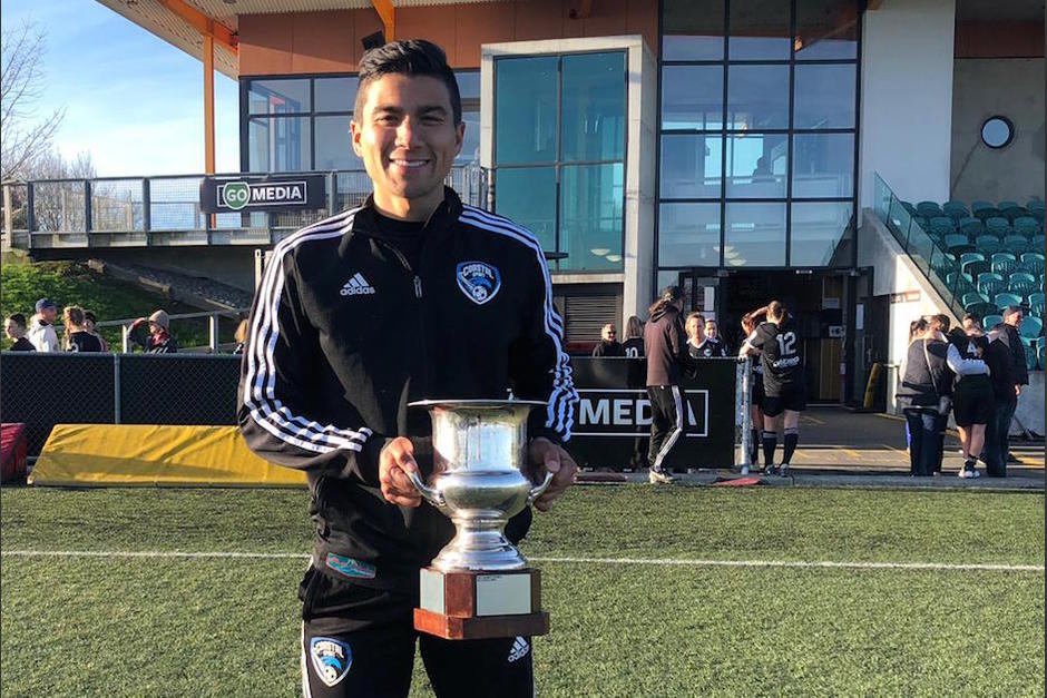 Juan José Chang muestra uno de los títulos obtenidos con el equipo femenil que dirige en Nueva Zelanda. (Foto: Cortesía)