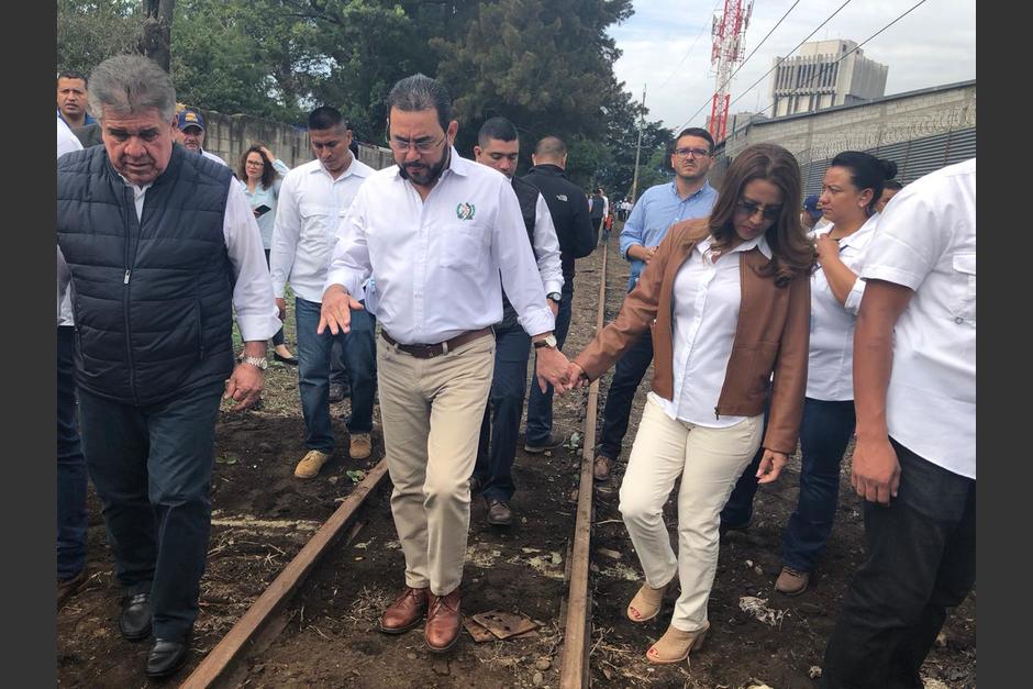 El presidente Jimmy Morales y su esposa Patricia de Morales se vieron obligados a caminar entre el lodo, luego que "La Chula" se descarrilara en el acto de inauguración. (Foto: Fredy Hernández/Soy502)