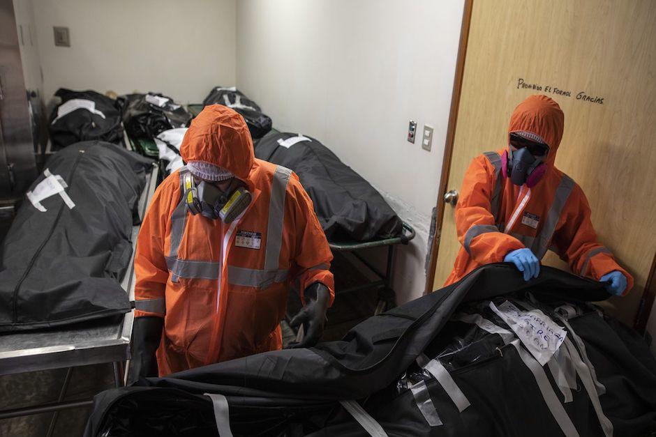 Trabajadores del Ministerio P&uacute;blico mostraron el cad&aacute;ver de un fallecido por Covid-19 tirado en el suelo y envuelto en una bolsa pl&aacute;stica. (Foto ilustrativa: Chicago Tribune)