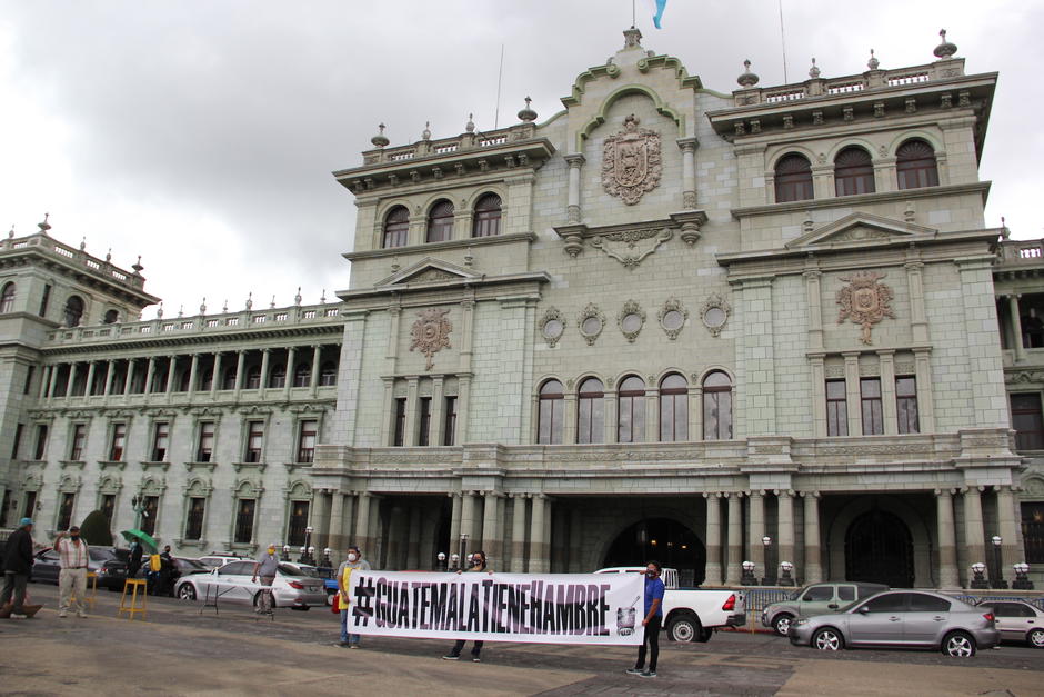Antes de iniciar la entrega de comida, los integrantes de la Olla Comunitaria desplegaron una manta con la leyenda #GuatemalaTieneHambre. (Foto: Fredy Hernández/Soy502)