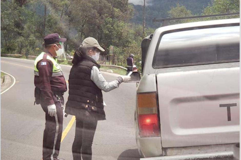 Empleados municipales hacen un cobro de cinco quetzales por fumigar las llantas de los vehículos que ingresan al municipio de San Marcos, desde la zona costera. (Foto: Soy502)
