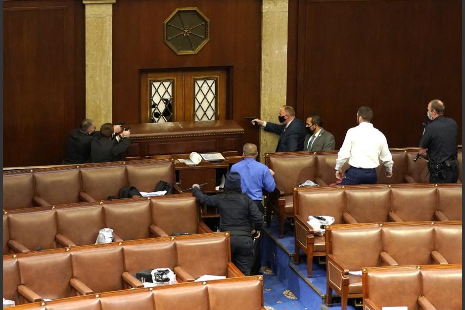 Agentes de la policía desenfundaron sus armas dentro del Congreso de EE.UU. para resguardar a los legisladores de una turba que irrumpió en el Capitolio. (Foto: AFP)
