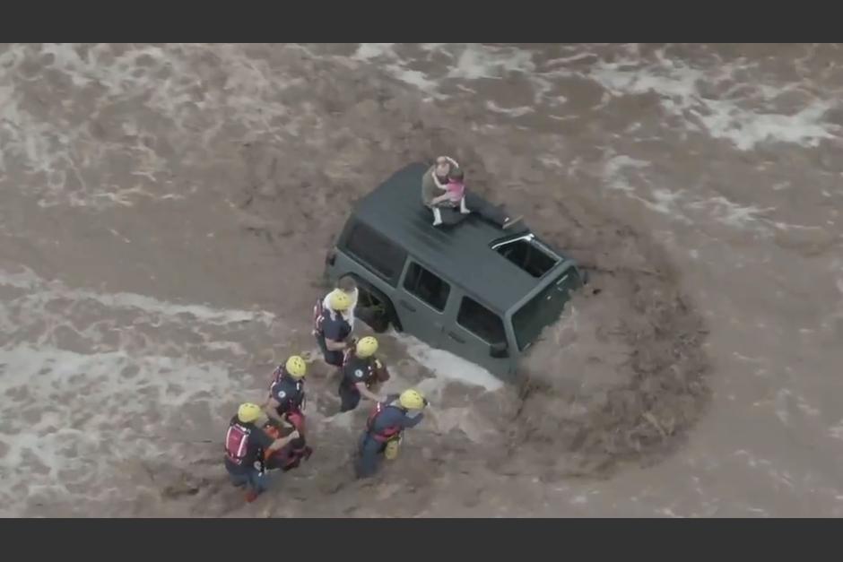 Un hombre y sus dos hijas fueron rescatados tras quedar atrapados en un vehículo que fue arrastrado. (Foto: actualidad.rt.com)