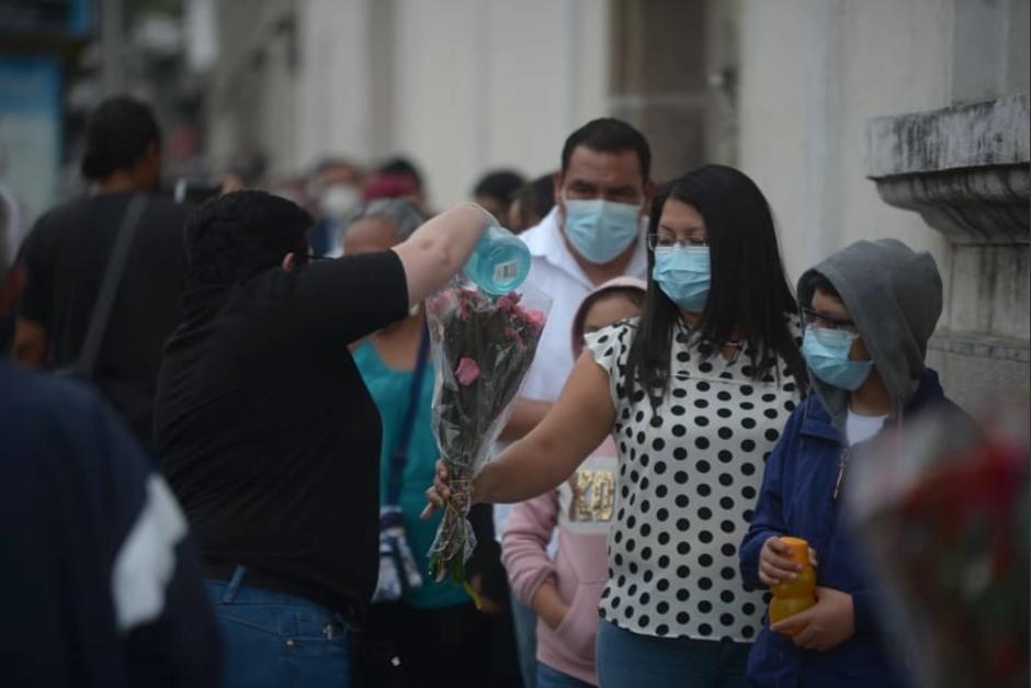 Guatemaltecos hacen fila en las afueras del templo para depositar sus flores en el altar. (Foto: Wilder López/Soy502)