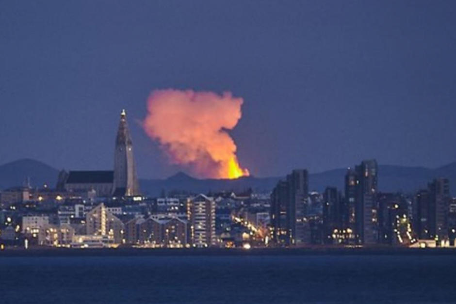 Vista de la ciudad de Reikiavik, se pueden apreciar&nbsp;los g&eacute;iseres de un color naranja brillante iluminan el cielo. (Foto: AFP)