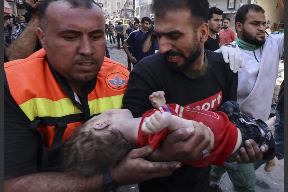 Mohamad al Hadidi sostiene en brazos, tembloroso, a su bebé Omar, el único miembro de su familia que sobrevivió. (Foto: AFP)