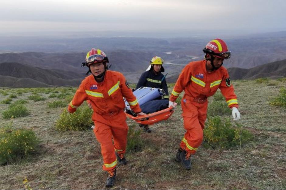 Los rescatistas cargando a uno de los fallecidos. (Foto: AFP)