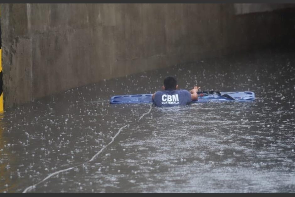 Socorristas utilizaron lazos para rescatar a personas atrapadas en el techo de un bus extraurbano en una inundación del paso a desnivel de la Aguilar Batres. (Foto: Bomberos Municipales)