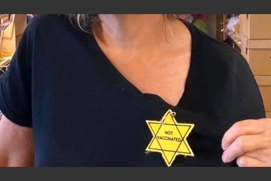 En la imagen se ve a una mujer, supuestamente la propietaria del negocio, con una estrella de David amarilla con el mensaje "no vacunada" en su camiseta negra.&nbsp;&nbsp;(Foto: télam)