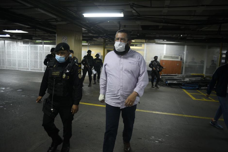 Otto Gómez camina en el sótano de tribunales y el grupo de agentes de la PNC que participó en el operativo de captura atrás. (Foto: Wilder López/Soy502)&nbsp;