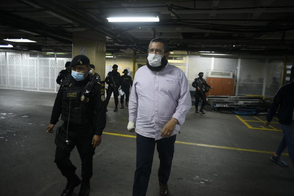 Otto G&oacute;mez camina en el s&oacute;tano de tribunales y el grupo de agentes de la PNC que particip&oacute; en el operativo de captura atr&aacute;s. (Foto: Wilder L&oacute;pez/Soy502)&nbsp;