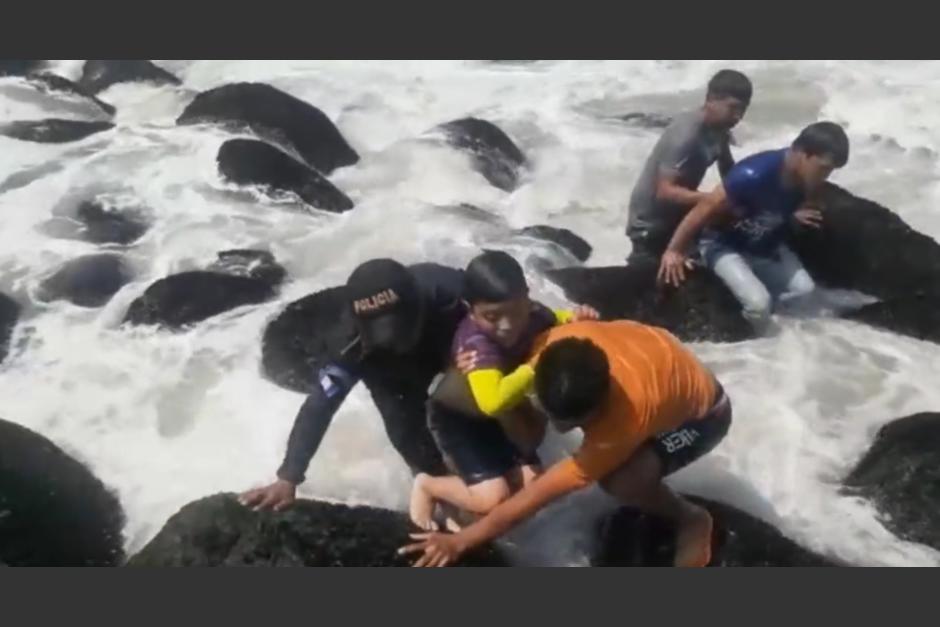 Un agente de la PNC fue captado mientras contribu&iacute;a en el rescate de un ni&ntilde;o que se estaba ahogando en Champerico, Retalhuleu. (Foto: captura de video)