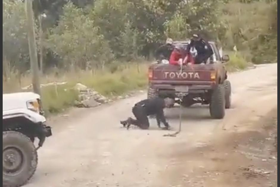 Un agente de la PNC cayó de un pick up, luego de desprenderse la cadena que intentaba jalar a otro vehículo. (Foto: captura video)