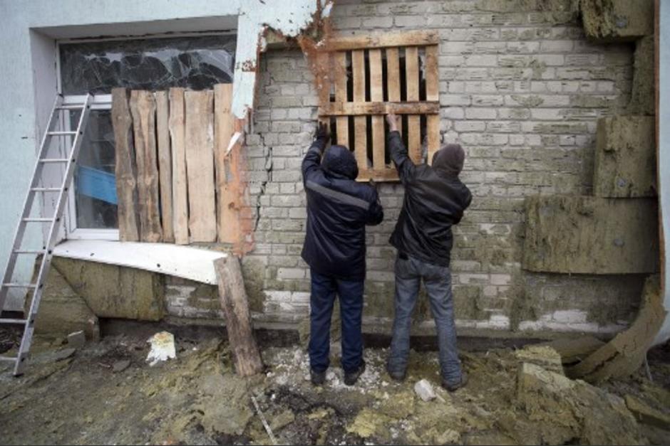 Los residentes locales de la aldea de Stanytsia Luhanska, regi&oacute;n de Luhansk, controlada por Ucrania, reparan despu&eacute;s del bombardeo de los separatistas respaldados por Rusia el 18 de febrero de 2022. (Foto: AFP)