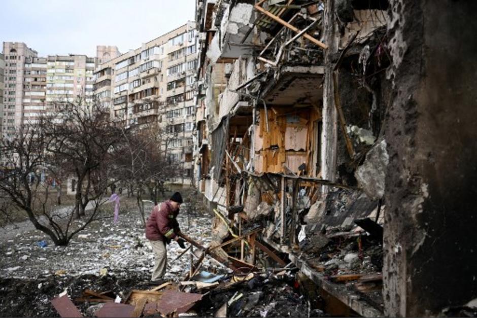 Un hombre limpia los escombros en un edificio residencial dañado en la calle Koshytsa, un suburbio de la capital ucraniana, Kiev. (Foto: AFP)