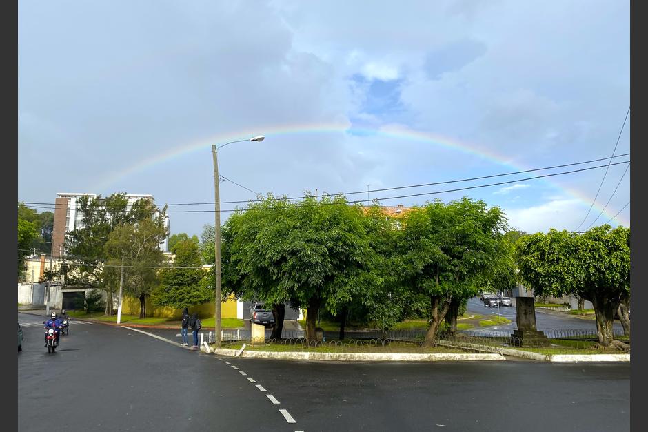 Mientras cientos de guatemaltecos retornan a casa, un arcoíris pinta la tarde lluviosa de colores. (Foto: Fredy Hernández/Soy502)