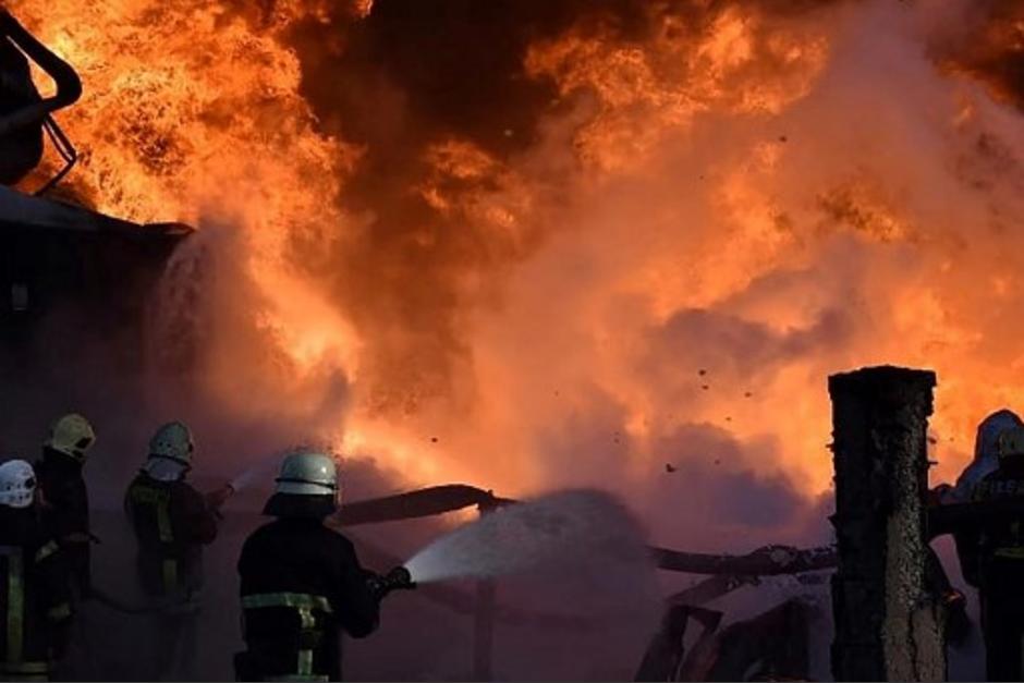 Esta imagen fue distribuida por el Servicio Estatal de Emergencias de Ucrania y muestra a los bomberos tratando de extinguir un incendio que se desató en uno de los sitios industriales de almacenamiento de combustible en Lutsk, en el noroeste de Ucrania, como resultado del bombardeo. (Foto: AFP)
