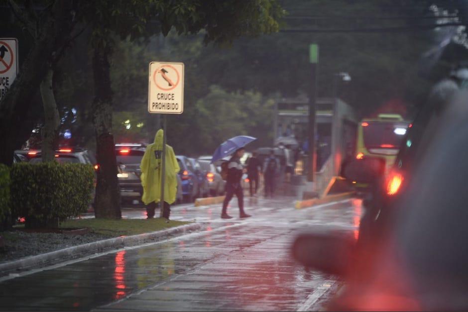 Los motoristas buscan resguardarse de la fuerte lluvia. (Foto: Wilder López/Soy502)