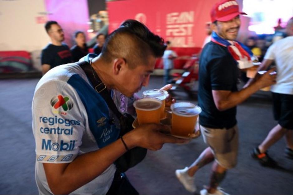 Los aficionados se aferraron hacia la &uacute;nica venta de cerveza permitida en Qatar. (Foto: AFP)