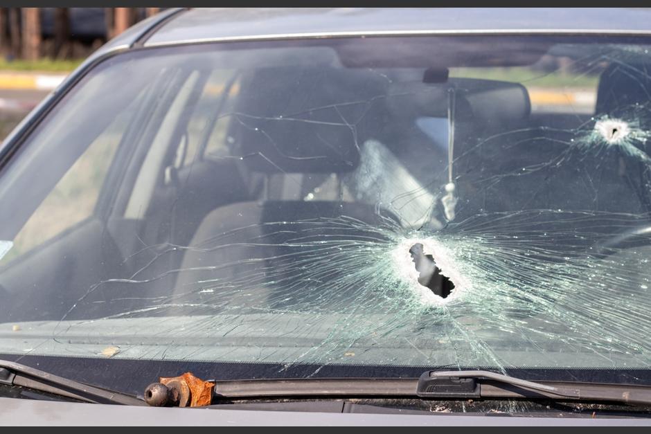 Uno de los hombres baja del carro y dispara a un carro estacionado. (Foto: Shutterstock)&nbsp;