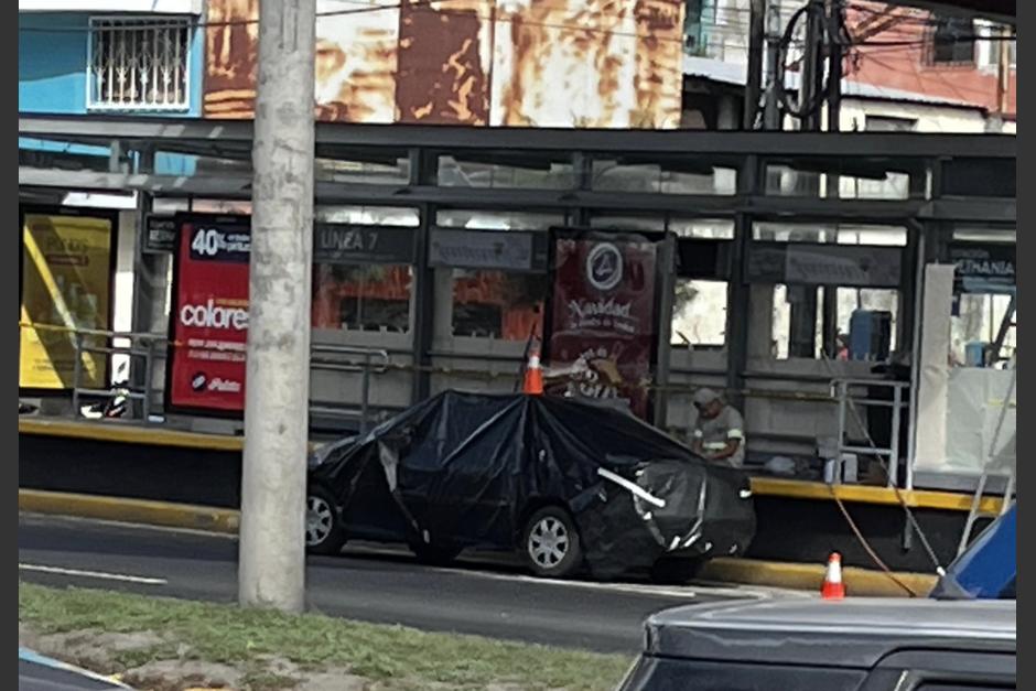 Un vehículo cubierto con una manta plástica en una estación de Transmetro despertó la curiosidad de conductores. (Foto: cortesía/Soy502)