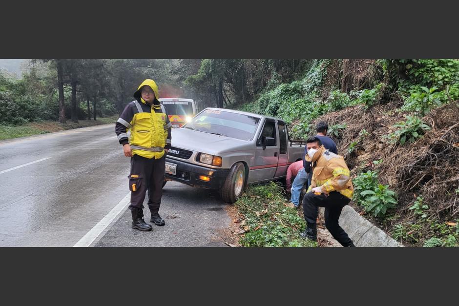 Bomberos auxilian a tripulantes de un pick up que derrapó en la bajada las Cañas, camino a la Antigua Guatemala. (Foto: Bomberos Voluntarios)