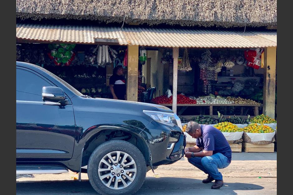 Un hombre intenta tapar la placa oficial del vehículo durante una actividad del binomio presidencial de Vamos. (Foto: Cortesía)