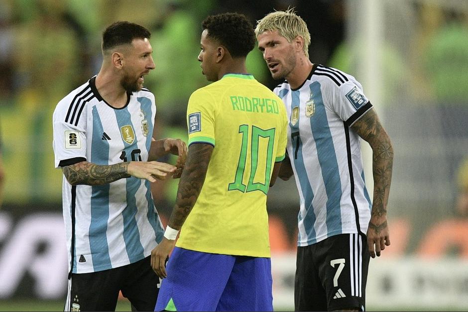 Los argentinos Leo Messi y Rodrigo de Paul, confrontando al brasileño Rodrygo Goes. (Foto: AFP)